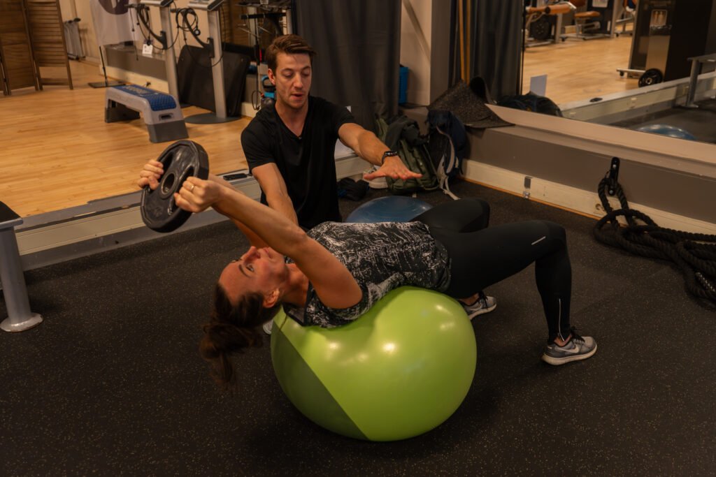 Een vrouw die een oefening aan het doen is met een personal training met als doel af te vallen zonder spiermassa te verliezen