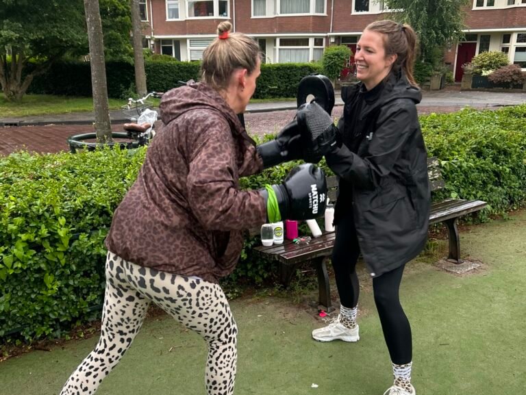 Twee deelnemers outdoor aan het boksten bij een outdoor training van JPA personal training